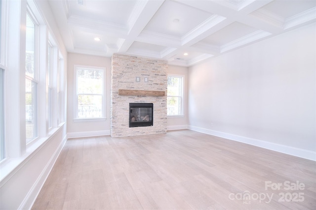 unfurnished living room featuring light wood-style floors, a healthy amount of sunlight, beamed ceiling, and a fireplace