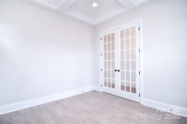 spare room featuring light wood finished floors, french doors, baseboards, and crown molding