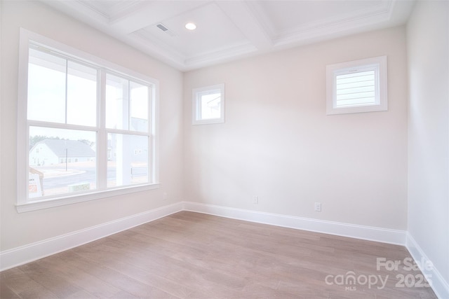 unfurnished room featuring coffered ceiling, baseboards, ornamental molding, light wood-type flooring, and beamed ceiling