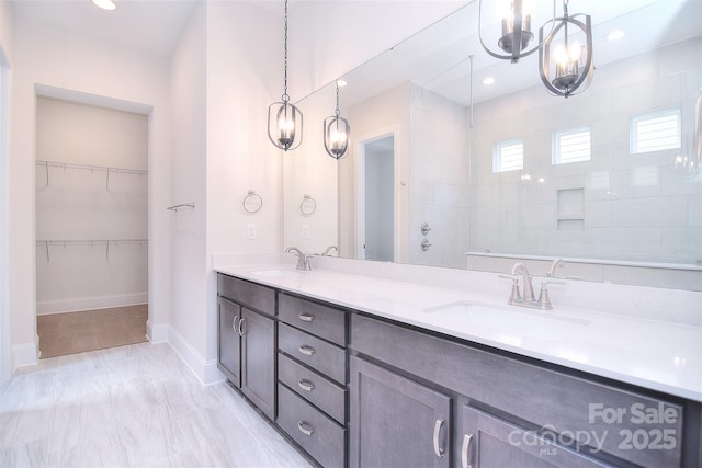 bathroom with recessed lighting, a sink, baseboards, and double vanity