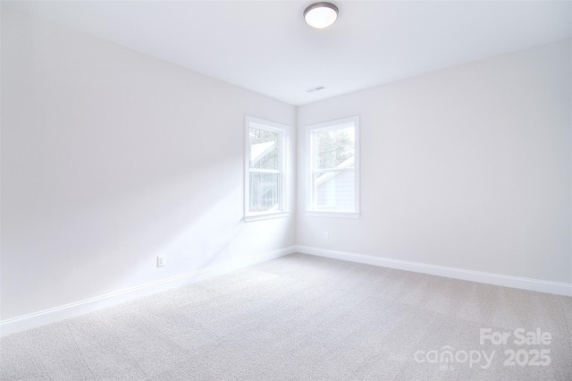 unfurnished room with light carpet and baseboards