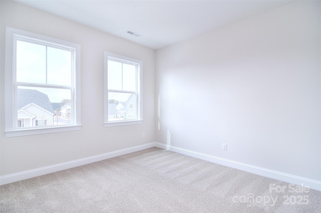 carpeted spare room with visible vents and baseboards