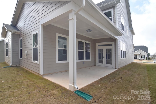 rear view of house featuring a patio, french doors, and a lawn