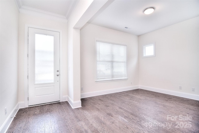 entrance foyer featuring dark wood-type flooring, ornamental molding, and baseboards