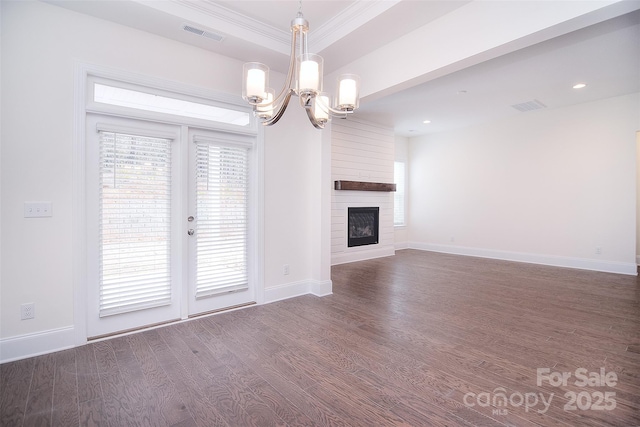 unfurnished living room with a notable chandelier, a fireplace, visible vents, dark wood-type flooring, and baseboards