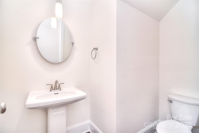 bathroom featuring toilet and baseboards