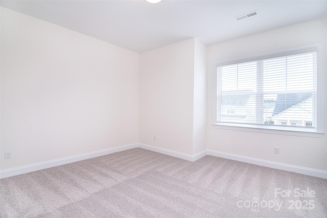 empty room featuring light carpet, baseboards, and visible vents