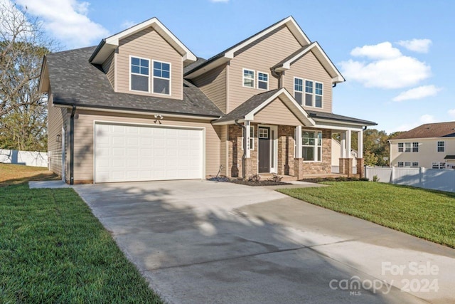 craftsman inspired home with a garage and a front lawn