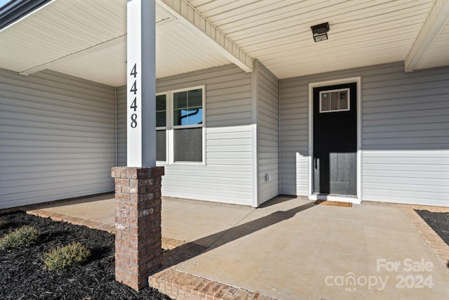 view of exterior entry with covered porch