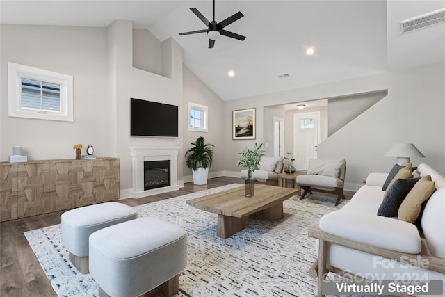 living room featuring hardwood / wood-style floors, high vaulted ceiling, and ceiling fan