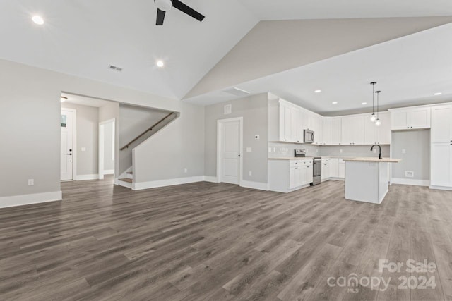 unfurnished living room featuring ceiling fan, sink, high vaulted ceiling, and hardwood / wood-style flooring