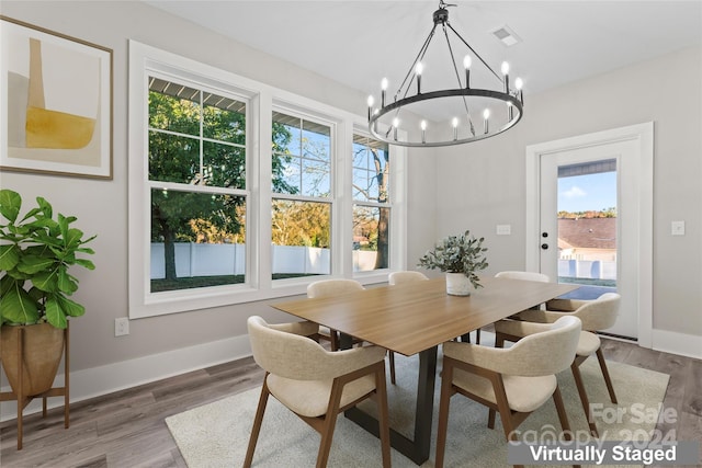 dining area featuring hardwood / wood-style flooring and an inviting chandelier