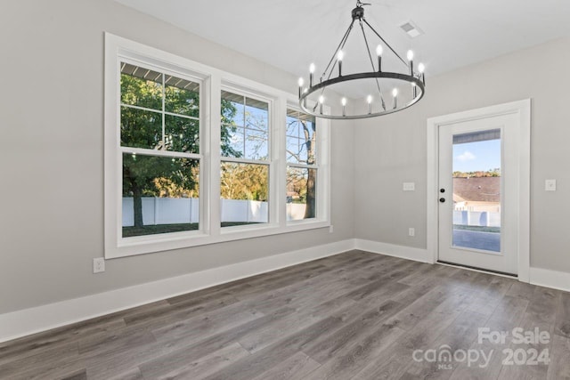 unfurnished dining area with hardwood / wood-style flooring and an inviting chandelier