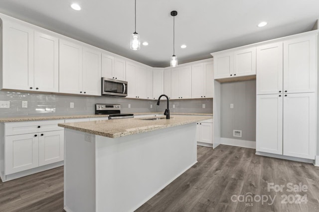 kitchen with pendant lighting, sink, light stone counters, white cabinetry, and stainless steel appliances