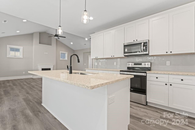 kitchen with white cabinets, appliances with stainless steel finishes, and a kitchen island with sink