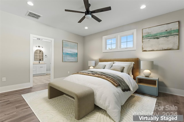 bedroom with wood-type flooring, ensuite bath, and ceiling fan