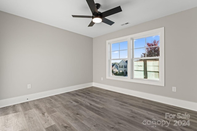 spare room with a wealth of natural light, hardwood / wood-style floors, and ceiling fan