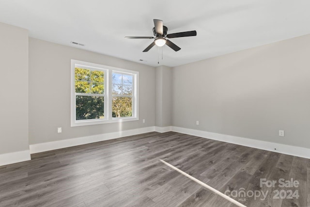 unfurnished room with dark hardwood / wood-style flooring and ceiling fan