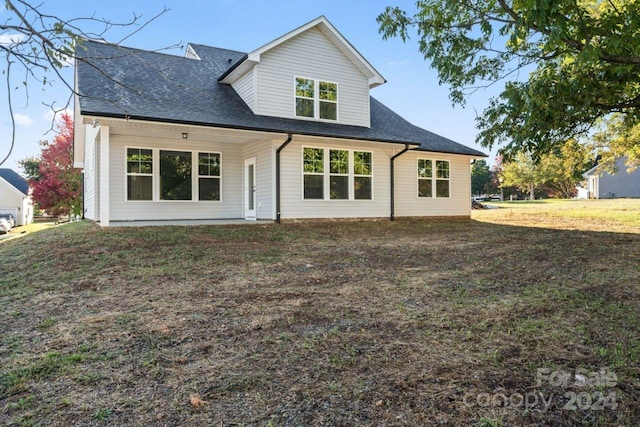 rear view of house featuring a yard