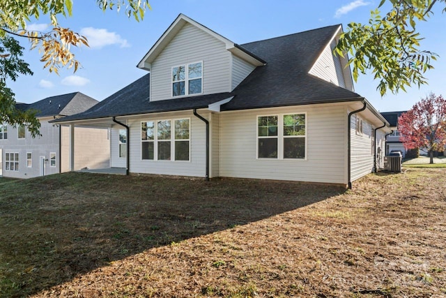 back of property featuring central AC unit and a lawn