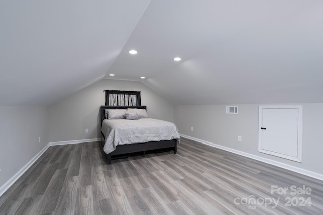 bedroom with vaulted ceiling and dark wood-type flooring