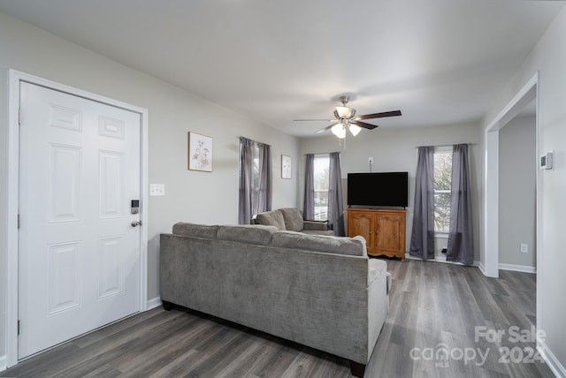 living room with ceiling fan and dark wood-type flooring