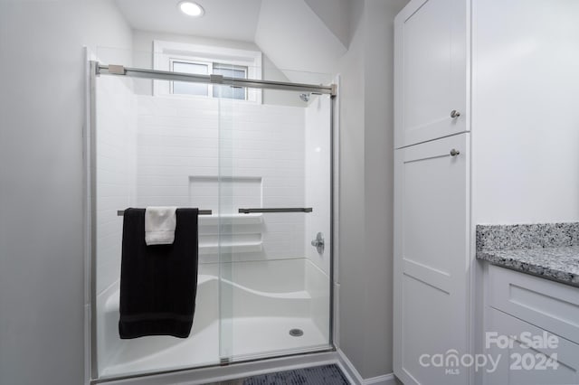 bathroom with vanity and a shower with shower door