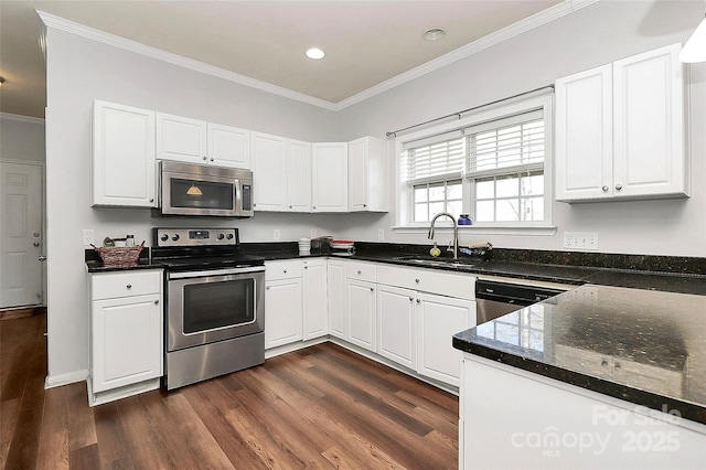 kitchen with dark wood finished floors, crown molding, appliances with stainless steel finishes, white cabinets, and a sink