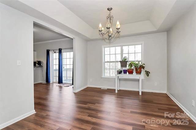 interior space featuring dark hardwood / wood-style flooring, a chandelier, and a tray ceiling