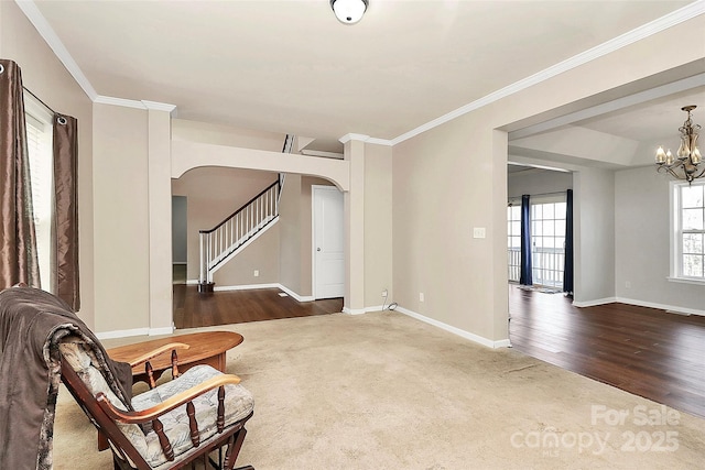 sitting room with dark wood-type flooring, a notable chandelier, and crown molding