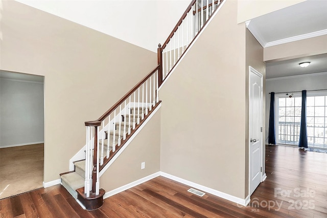 stairway featuring ornamental molding and hardwood / wood-style flooring