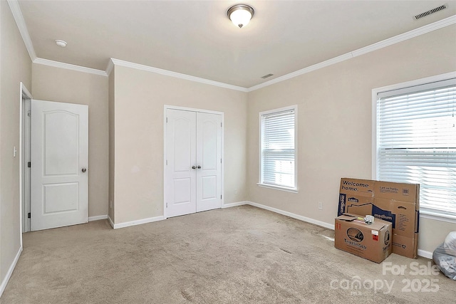 unfurnished bedroom with ornamental molding, a closet, and light carpet