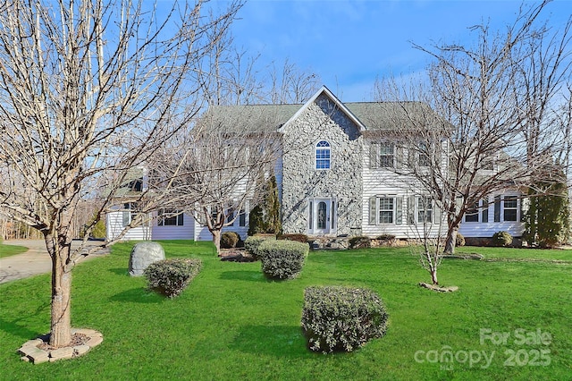 colonial inspired home with a front lawn