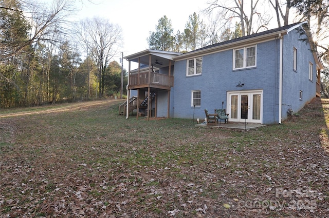 rear view of property with ceiling fan, a yard, french doors, a deck, and a patio