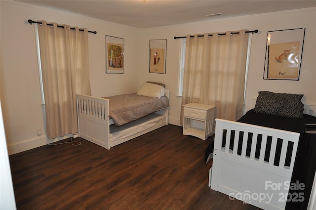 bedroom with dark hardwood / wood-style floors and crown molding