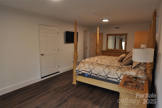 bedroom with dark hardwood / wood-style flooring and ornamental molding