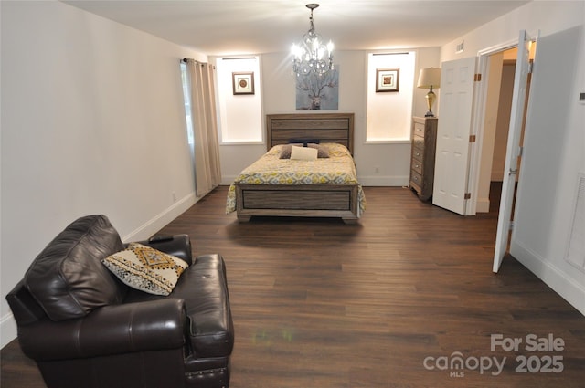 bedroom featuring a chandelier, multiple windows, and dark wood-type flooring