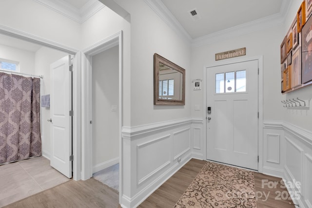 entrance foyer featuring light hardwood / wood-style floors and ornamental molding