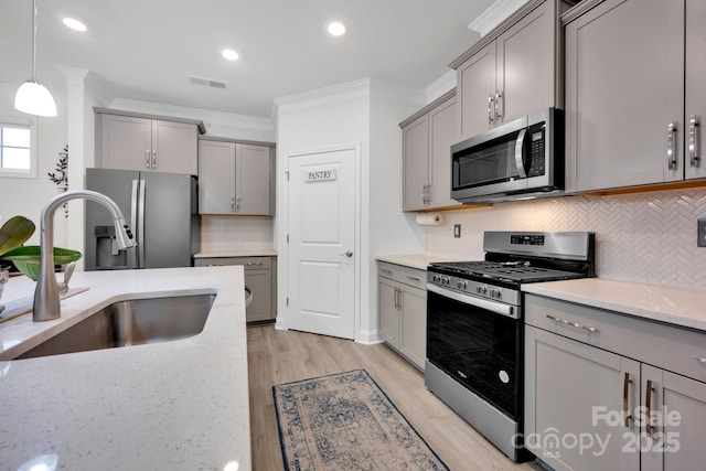 kitchen featuring decorative backsplash, pendant lighting, stainless steel appliances, and sink