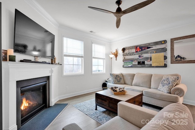 living room featuring light hardwood / wood-style flooring, ceiling fan, and ornamental molding