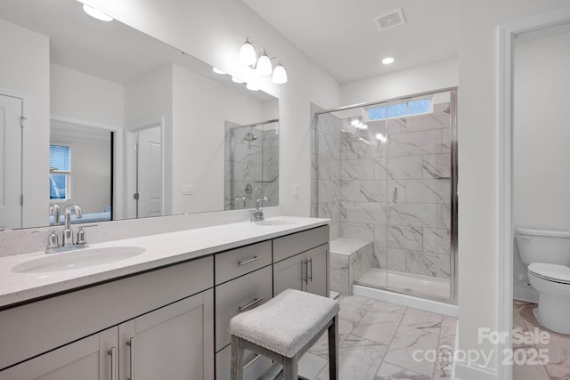 bathroom featuring vanity, toilet, and an enclosed shower