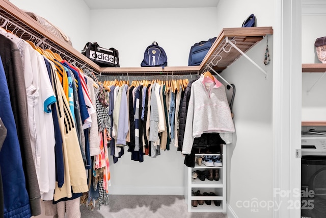 spacious closet featuring carpet floors and washer / clothes dryer