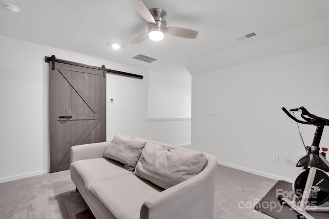 interior space with a barn door, carpet floors, and ceiling fan