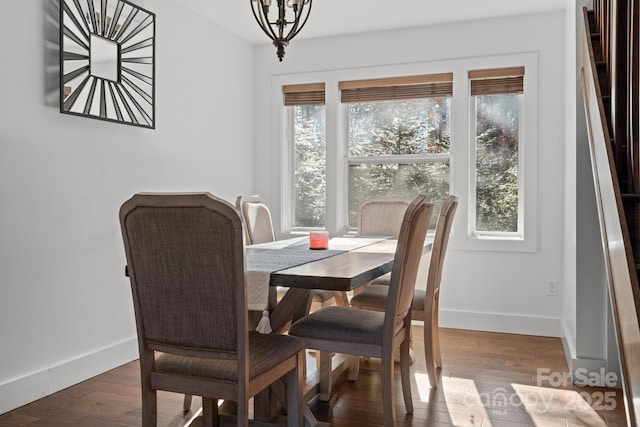 dining area with dark hardwood / wood-style floors and a chandelier