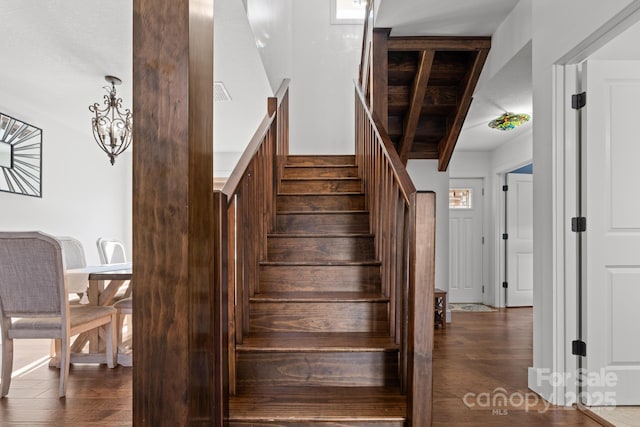 stairway with hardwood / wood-style flooring and beam ceiling