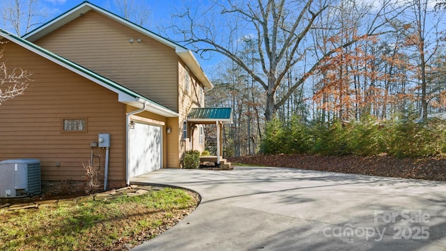 view of home's exterior with a garage and cooling unit