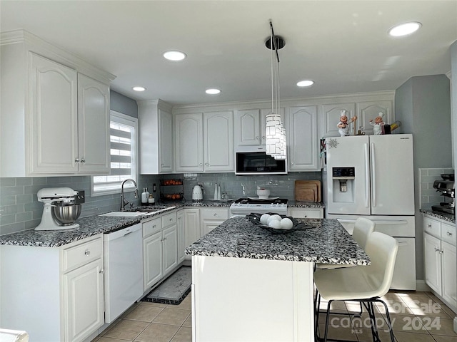 kitchen featuring a center island, sink, white appliances, decorative backsplash, and white cabinets