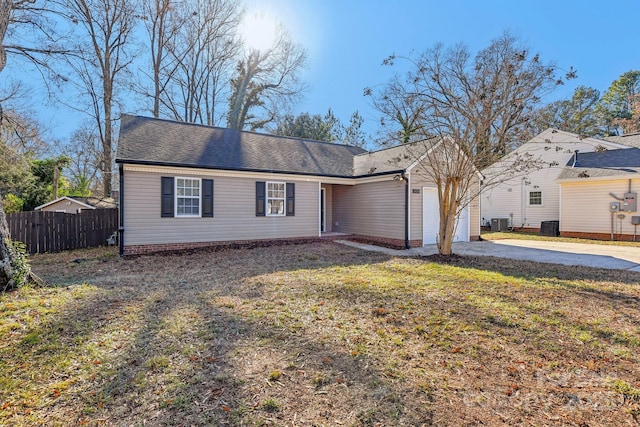 ranch-style house featuring central air condition unit, a front lawn, and a garage