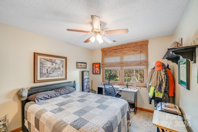 bedroom featuring a textured ceiling, ceiling fan, and light carpet