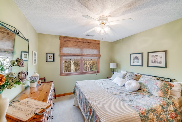 carpeted bedroom featuring ceiling fan and a textured ceiling